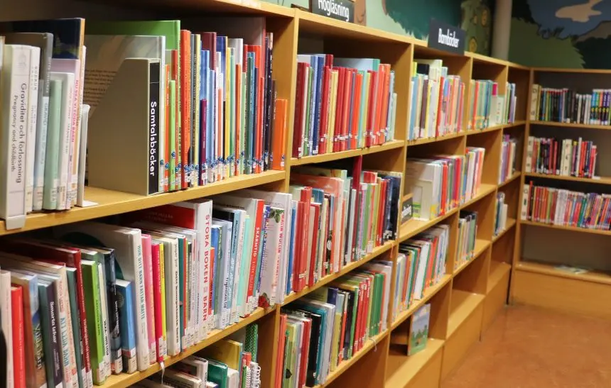 Lång bokhylla med färgglada bokryggar.