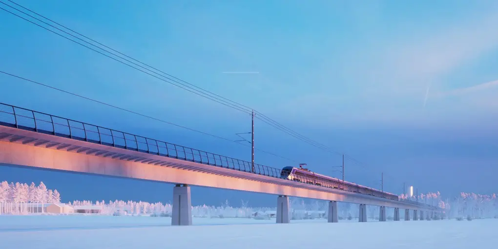 Belyst betongbro för tåg, vinterlandskap.
